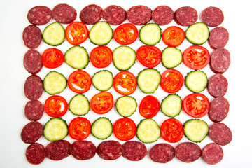 sliced ​​pieces of sausage, cucumber and tomato on a white background. fast food and breakfast