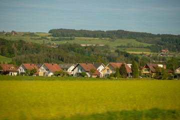 Fototapeta na wymiar Wooden houses in small town and field in rural area of switzerland for background with copy space