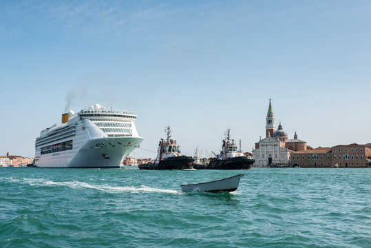Gigantic cruise ship with tourists leaving Venice, San Giorgio Maggiore church, Venezia, Italy - Powered by Adobe