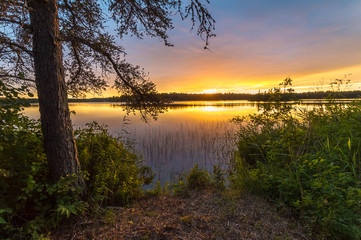 Fototapeta na wymiar A beautiful sunset view of a calm and peaceful lake in Northwest Ontario, Canada.