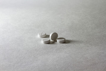 Closeup white little many pills on white light table background.