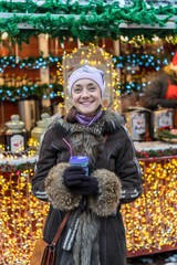 Happy laughing woman. Beautiful woman in winter clothes with coffee in hand On the background of beautiful bokeh. outdoor. vertical photo