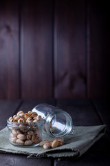 Pistachios in glass jars on a wooden background