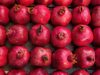 Red ripe pomegranate fruit lie in a box