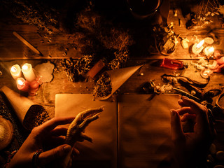 In the hands of witches chicken leg for divination. The light from the candles on the old magic...