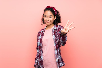 Asian young woman over isolated pink background happy and counting three with fingers