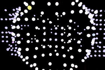 A lot of bright circles on a black background. Depth space. Abstract of the balls. Glowing planets in the air. Balls diverge from the cent as after a drop of water.