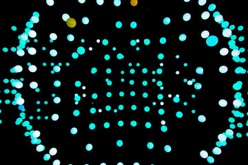 Abstract glowing balls in the air. Many balls of different shapes on a black background. Turquoise...