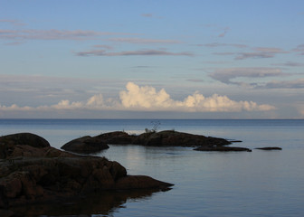 Rock formations, Lake Vanern and summer clouds at sunset.