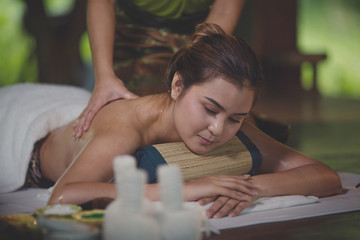 Obraz na płótnie Canvas Beautiful young asian woman lying relaxing and smile on the bed mattresses In the Spa. Thai massage for health. Select focus face women.