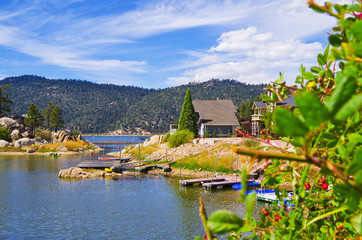 Panoramic view of Big Bear Lake in southern California with lakeside houses and people canoeing and kayaking