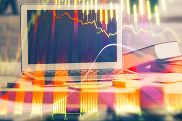 Financial graph colorful drawing and table with computer on background. Multi exposure. Concept of international markets.