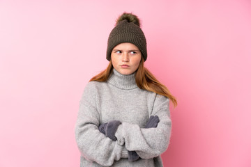 Ukrainian teenager girl with winter hat over isolated pink background thinking an idea