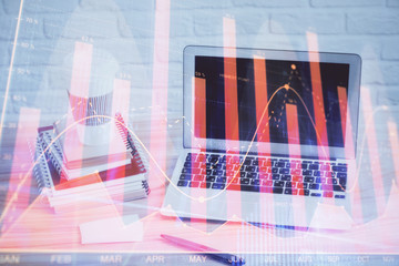 Stock market graph on background with desk and personal computer. Multi exposure. Concept of financial analysis.