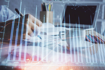 Financial chart drawn over hands taking notes background. Concept of research. Double exposure