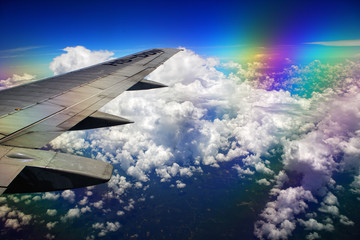 Airplane wing, clouds and sky during the flight. Shot with a polarizing filter for the lens.
