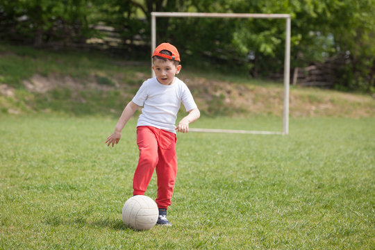 Little boy kicking ball in the park. playing soccer (football) in the park. Sports for exercise and activity.