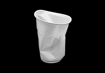 Fototapeta na wymiar Crumpled plastic white Cup isolated on black Background