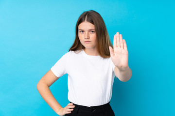 Fototapeta premium Ukrainian teenager girl over isolated blue background making stop gesture with her hand