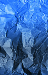 Photo of crumpled paper texture in classic blue color. Color of the year 2020.