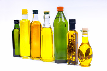 Various bottles with olive oil on a white background