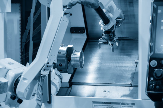 The CNC lathe machine operation  with automatic loader by robotic arm  . The automatic robotic  system manufacturing process with CNC turning machine .