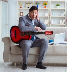 Businessman playing guitar at home