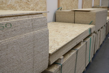 Stacked sheets of  at the beginning of the shopping row in a wholesale building goods store. 