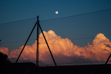 Clouds at sunset with the moon in the background