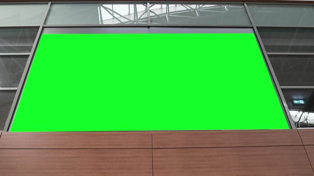 Empty blank widescreen billboard with green screen, alpha channel. Chroma key frame on airport hall, big banner for marketing. 