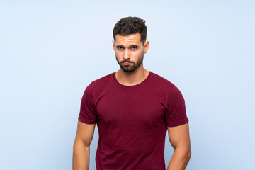 Fototapeta premium Handsome man over isolated blue background with sad and depressed expression
