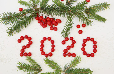 Naklejka na ściany i meble Christmas or New Year composition, background 2020 with spruce and red berries on a white background. Flat lay. Top view. Card, Background.