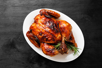 Homemade Roasted chicken with rosemary served on white plate.