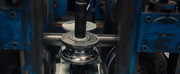 Fototapeta premium Industrial metal sheet coils connected with metal sheet profile forming machine