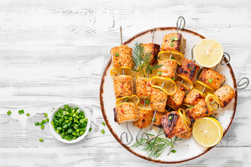 Baked salmon skewers with lemon and green onion.