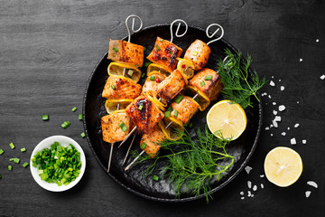 Baked salmon skewers with lemon and green onion.