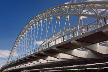 Jogger on new Strandherd Armstrong steel suspension bridge over the Rideau River Ottawa