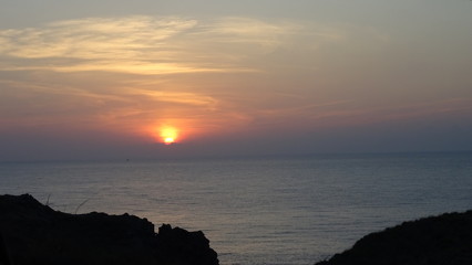 Obraz premium sonnenuntergang mit wolkenschleiern an der felsenküste bei almeria