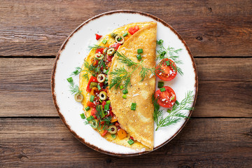 Healthy breakfast food, Stuffed egg omelette with tomato , grilled pepper, green olives and parmesan cheese.