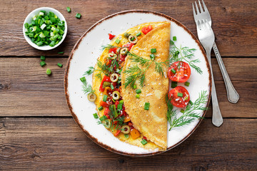 Healthy breakfast food, Stuffed egg omelette with tomato , grilled pepper, green olives and parmesan cheese.