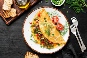 Healthy breakfast food, Stuffed egg omelette with tomato , grilled pepper, green olives and parmesan cheese.