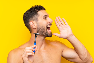 Man shaving his beard shouting with mouth wide open