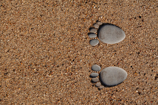 Human foot made of stone on the beach