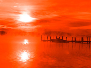 Sunrise at a lake shore with charming mist and lovely boat!