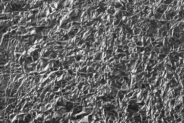 Crumpled silver aluminum foil background, abstract texture