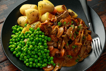 Classic beef stroganoff servei with boiled baby potato and sweet peas