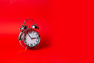Metal Alarm clock  on red background , isolated 