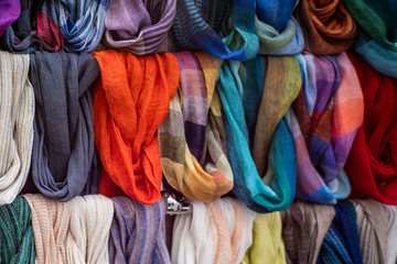 a rack with various and colorful summer scarves from a street vendor.