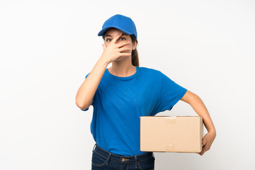 Young delivery girl over isolated white background covering eyes and looking through fingers