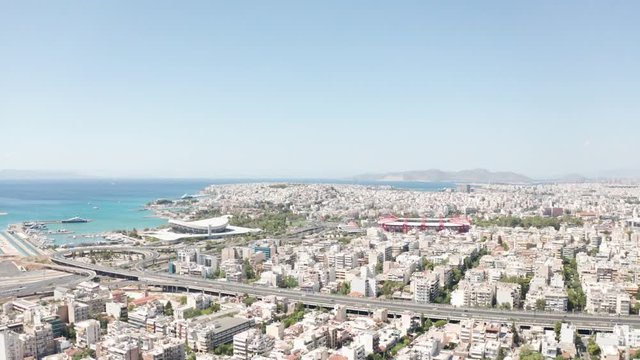 Aerial drone flight towards the two stadiums of Sef and Karaiskaki over the city of Piraeus